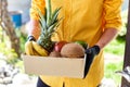 Courier man delivery box with exotic fruits food, contactless delivery