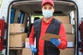 Courier man in front of cargo van delivering package to customer - Focus on left hand Royalty Free Stock Photo