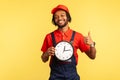 Courier man holds clock and showing thumbs up, like gesture, satisfied with delivery service on time