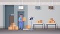 Courier man in uniform putting parcel box on scales mail express delivery logistic service concept modern warehouse
