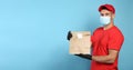 Courier in medical mask holding paper bag with takeaway food on light blue background, space for text. Delivery service during Royalty Free Stock Photo