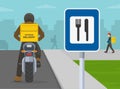 Courier on motorcycle with yellow parcel box on the back delivering food. Back view. Close-up view of a restaurant or cafe sign.