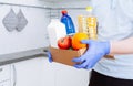 Courier in protective medical gloves delivers box with set food stock for quarantine isolation period. Organic food and products Royalty Free Stock Photo