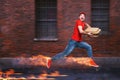 Courier runs fast to deliver quickly pizzas with fiery feet. Cyan background Royalty Free Stock Photo
