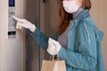 Courier`s hands in black medical gloves deliver parcels in paper bag to the door during the epidemic coronovirus, COVID