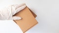 Courier`s hands in latex white medical gloves deliver parcels in brown cardboard boxes to the door during the epidemic of