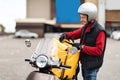 Courier On Scooter Opening Yellow Food Delivery Bag Standing Outside