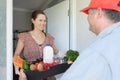 Courier service man delivering grocery home delivery order to a