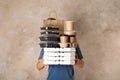 Courier with stack of orders on beige background. Royalty Free Stock Photo