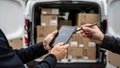 Courier Utilizes Tablet For Contactless Delivery, Courier Exchanges Pen And Device To Sign For Package At Delivery Point Royalty Free Stock Photo