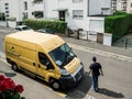 Courier walking toward La Poste yellow delivery van