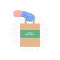 Couriers hand in blue protective rubber glove holding delivery paper bag with food. Safe food delivery.