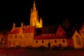 Court of the Old Saint John hospital in Bruges at night with tower of church of our lady behind