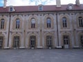 The exterior wall of a Polish palace with many arches, windows and a roof with atticks