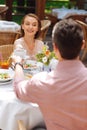 Courteous dark-haired man giving cup of tea to his girlfriend