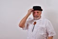 Courteous senior man looking serious is tipping his hat Royalty Free Stock Photo
