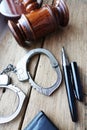 Courthouse verdict concept with justice objects as judge gavel and handcuffs on wooden desk