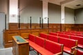 Courtroom interior court defendant box with red benches for defense and spectator Royalty Free Stock Photo
