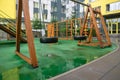 A courtyard of high-rise buildings with a modern and large playground made of wood and plastic on a rainy summer day without Royalty Free Stock Photo