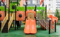 A courtyard of high-rise buildings with a new modern colorful and large playground on a rainy summer day without people. Empty Royalty Free Stock Photo