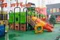 A courtyard of high-rise buildings with a new modern colorful and large playground on a rainy summer day without people. Empty Royalty Free Stock Photo