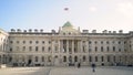 Courtyard inside white Palace. Action. Tourists walk in square on background of facade of white European Palace with