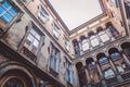 The courtyard of the old house from the inside, dirty walls and large windows, a historic building, shabby Royalty Free Stock Photo