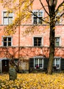 Courtyard with old rustic house front in typical northeast Swiss architecture and autumn color tree and leaves in the foreground