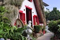 Courtyard of an old traditional house in Santana Madeira Island with red windows and a thatched roof Portugal Royalty Free Stock Photo