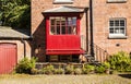 Courtyard with redbrick house and iron steps leading to a red po