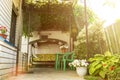 The courtyard of the small house with the resting place under a natural shadow canopy of vine plants and garden swing sofa in the Royalty Free Stock Photo