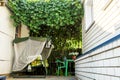 The courtyard of the small house with the resting place under a natural shadow canopy of vine plants and garden swing sofa in the Royalty Free Stock Photo