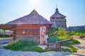 The courtyard of Small Kish in Zaporizhian Sich scansen with log house, wooden sculpture and high tower on background, Royalty Free Stock Photo