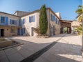 Courtyard in the south of France with a villa with stone walls and tiled roofs in sunlight