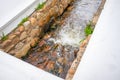 Courtyard water stream in Stellenbosch. Water gently flowing in a narrow stone moat.