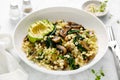 Couscous with avocado, spinach and sauteed champignon mushrooms with onion