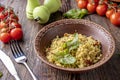 Couscous in bowl with olive oil and dried tomatoes on wooden background, oriental cuisine, horizontal photo