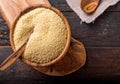 Couscous grain in wooden bowl. Top view