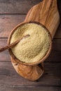 Couscous grain in wooden bowl. Top view