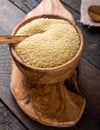 Couscous grain in wooden bowl. Top view