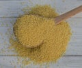 Couscous grain in a wooden spoon