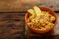 Couscous masfouf with dried fruits and nuts in a clay plate on a wooden board on the table.