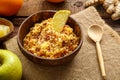 Couscous masfouf with dried fruits and nuts on a linen napkin next to a spoon and fresh fruit.