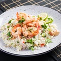 Couscous with roasted shrimps, tomatoes, red onions, almond nuts and parsley. Royalty Free Stock Photo