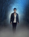 Cover of a fantastic novel. Handsome vampire walking in the woods Royalty Free Stock Photo