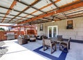 Covered back deck with concrete floor and outdoor furniture. Royalty Free Stock Photo