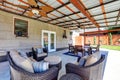 Covered back deck with concrete floor and outdoor furniture. Royalty Free Stock Photo