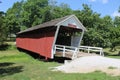 Covered Bridge Painted Red and White in a Forest