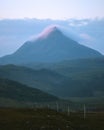 Covered by clouds illuminated by the rising sun, the summit of Mount Ben Stack Royalty Free Stock Photo
