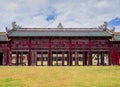 Covered corridor with red shutters and doors next to Can Thanh Palace, Hue forbidden city, Vietnam Royalty Free Stock Photo